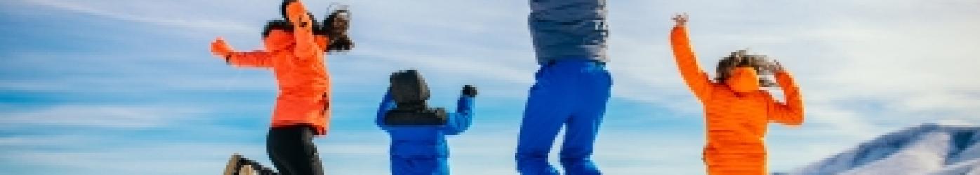 famille heureuse qui saute dans la neige 