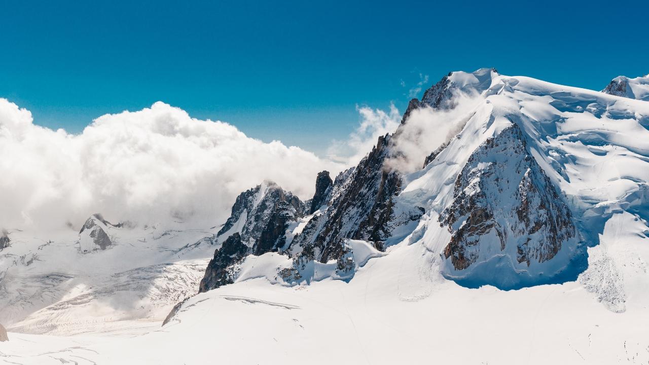 Montagnes enneigées avec ciel bleu et soleil radieux